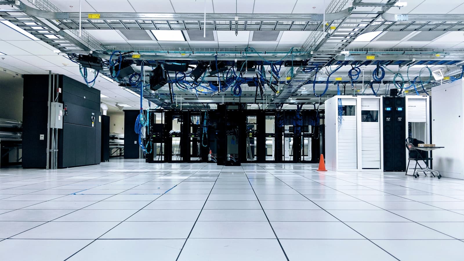 Long-exposure datacenter aisle with overhead cabling and rack hardware
